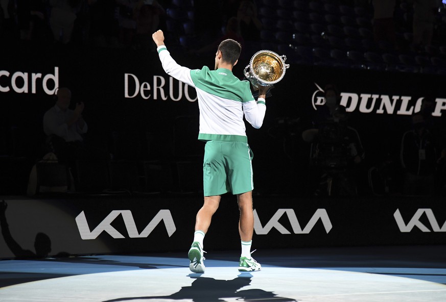 Serbia&#039;s Novak Djokovic holds the Norman Brookes Challenge Cup aloft after defeating Russia&#039;s Daniil Medvedev in the men&#039;s singles final at the Australian Open tennis championship in Me ...