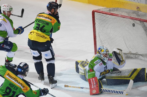 From left, Ambri&#039;s player Fabio Hofer scores the 1-1 goal, Ambri&#039;s player Matt D&#039;Agostini, center and Davos&#039;s goalkeeper Sandro Aeschlimann, during the preliminary round game of Na ...