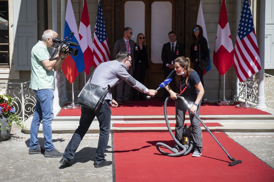 epaselect epa09275595 A staff member is interviewed while cleaning the red carpet in front of the villa La Grange, before the arrival of US President Joe Biden and Russian President Vladimir Putin dur ...