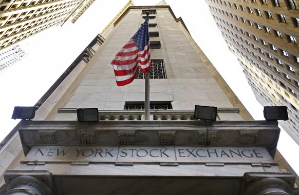FILE - In this Friday, Nov. 13, 2015, file photo, an American flag flies above the Wall Street entrance to the New York Stock Exchange. Intercontinental Exchange Inc. is considering a bid for the Lond ...
