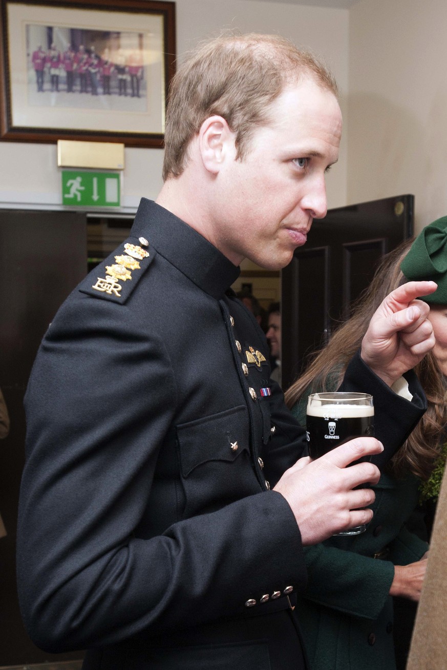 Prince William holds a pint of Guinness during a visit to the 1st Battalion Irish Guards at the St. Patrick&#039;s Day Parade at Mons Barracks, Aldershot, in England, Monday, March 17, 2014. The Duke  ...