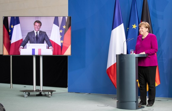epa08430503 French President Emmanuel Macron (L) and German Chancellor Angela Merkel (R) during a joint video press conference at the Chancellery in Berlin, Germany, 18 May 2020. France and Germany di ...