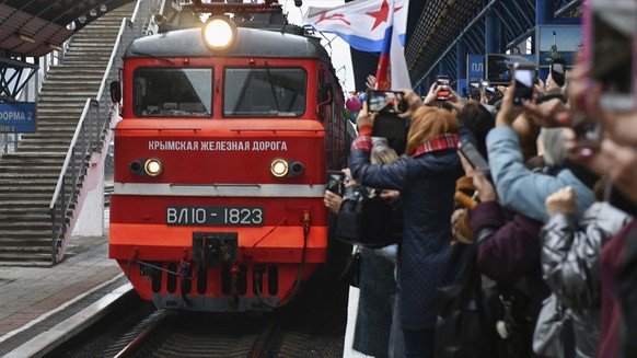People celebrate the arrival of the train from Russia in Sevastopol, Crimea, after it crossed a bridge linking Russia and the Crimean peninsula on Wednesday, Dec. 25, 2019. Ukrainian officials opened  ...