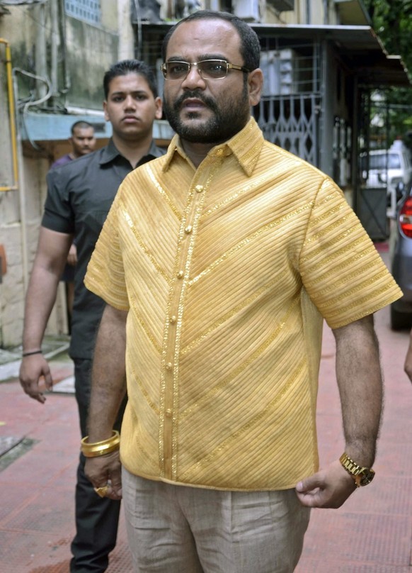 epa04343165 Indian businessman Pankaj Parakh (C) is escorted as he is wearing a four-kilograms shirt made of gold in Mumbai, India, 06 August 2014. According to reports, Pankaj Parakh would wear the s ...