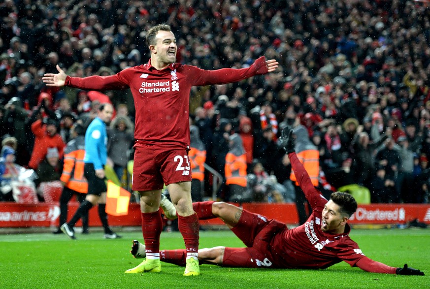 epa07236073 Xherdan Shaqiri (L) of Liverpool celebrates with teammate Roberto Firmino (R) after scoring during the English Premier League soccer match between Liverpool FC and Manchester United FC at  ...