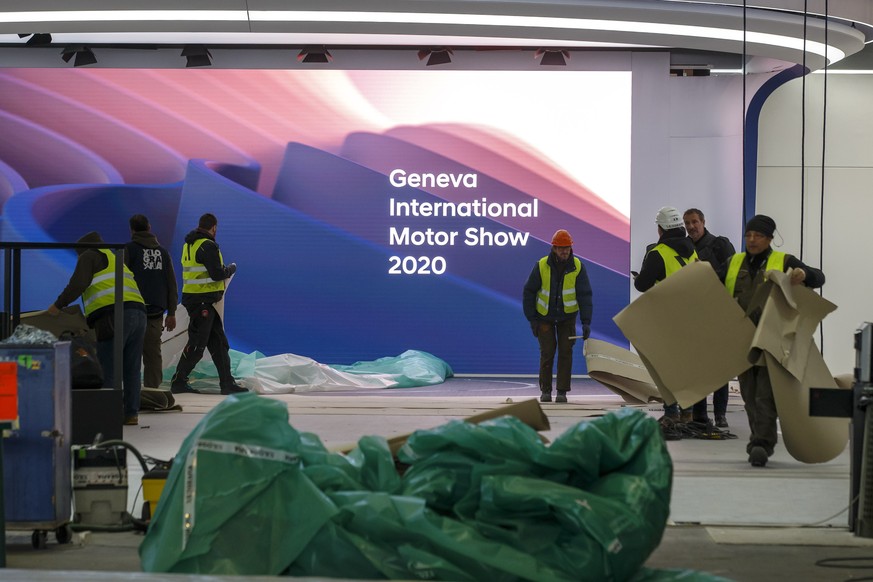 epa08255732 Workers dismantle a booth after the 90th Geneva International Motor Show (GIMS) was cancelled by Swiss authorities, at the Palexpo in Geneva, Switzerland, 28 February 2020 The 90th edition ...