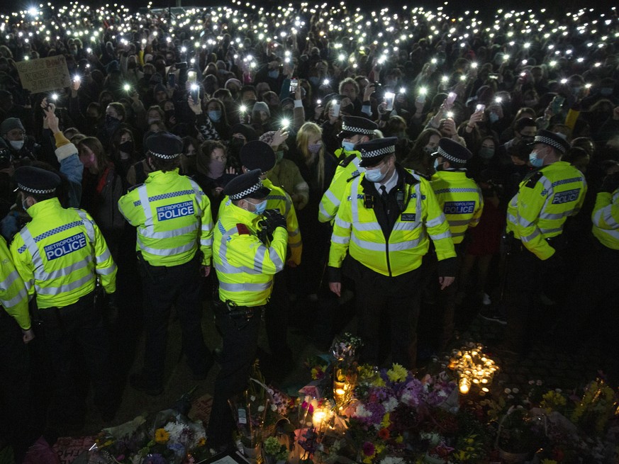 epa09073316 People attend a vigil by a band stand in Clapham Common, London, after the Reclaim These Streets vigil for Sarah Everard was officially cancelled in London, Britain, 13 March 2021 (issued  ...