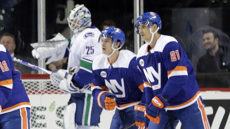 New York Islanders&#039; Josh Bailey (12) skates past Vancouver Canucks goaltender Jacob Markstrom (25) with teammates Mathew Barzal and Luca Sbisa (21) after scoring a goal during the first period of ...