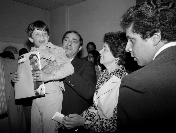 FILE ��� In this 1977 file photo, New York Secretary of State Mario Cuomo, is shown during a press conference with his family. He holds up his son Christopher, 6, as his wife Matilda, and son Andrew,  ...