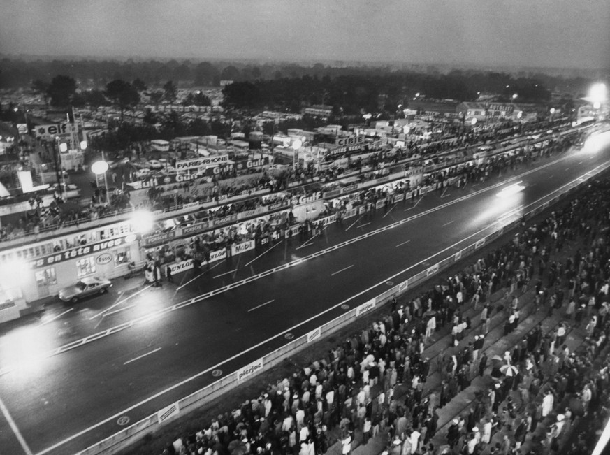 Die Autos des 24-Stunden-Rennen von Le Mans, passieren in der Nacht des 15. Juni 1970 die Zielgerade und die Boxengasse. (KEYSTONE/AP/Str)