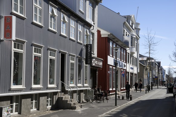 In this photo taken on Thursday, April 30, 2020, people walk down a street in downtown Reykjavik. High schools, dentists and hair salons are about to reopen in Iceland, which has managed to get a grip ...