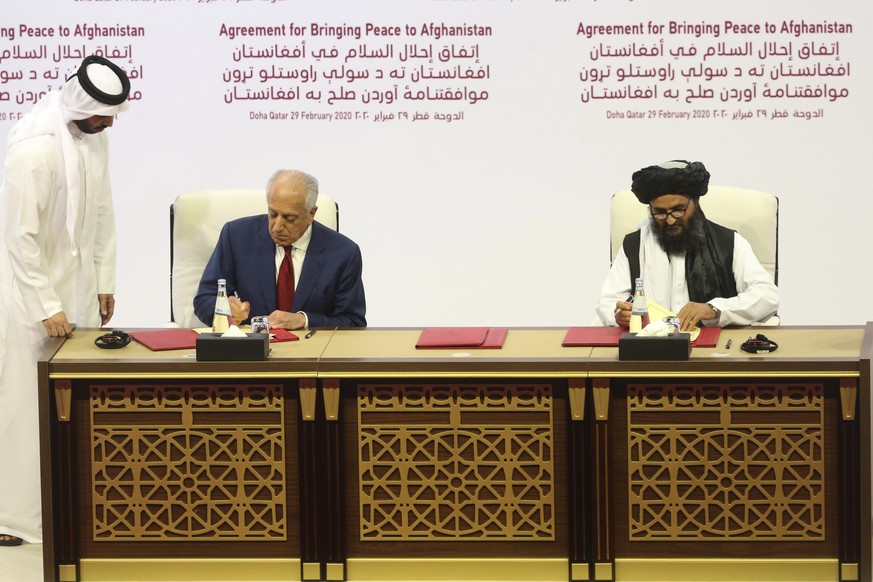 U.S. peace envoy Zalmay Khalilzad, left, and Mullah Abdul Ghani Baradar, the Taliban group&#039;s top political leader sign a peace agreement between Taliban and U.S. officials in Doha, Qatar, Saturda ...