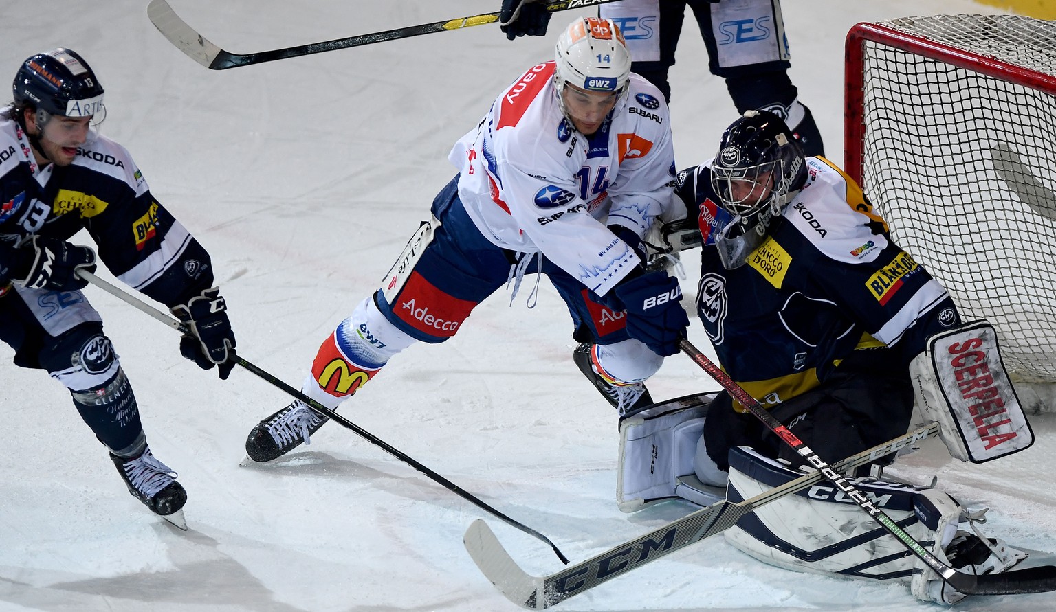 From left Ambri&#039;s player Marco Müller, Zsc&#039;player Chris Baltisberger and Ambri&#039;s goalkeeper Benjamin Conz, during the preliminary round game of National League A (NLA) Swiss Championshi ...