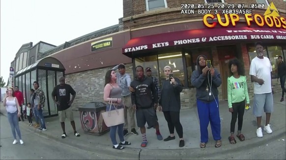 FILE - This May 25, 2020, file image from a police body camera shows bystanders including Alyssa Funari, left filming, Charles McMillan, center left in light colored shorts, Christopher Martin center  ...