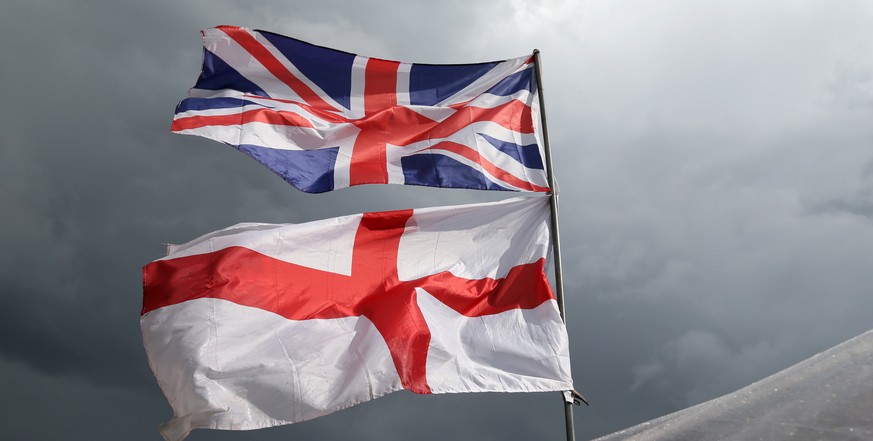 The flag of the United Kingdom of Great Britain and Northern Ireland, top, and the flag of England fly above a souvenir stand on Westminster Bridge following yesterday&#039;s EU referendum result, Lon ...