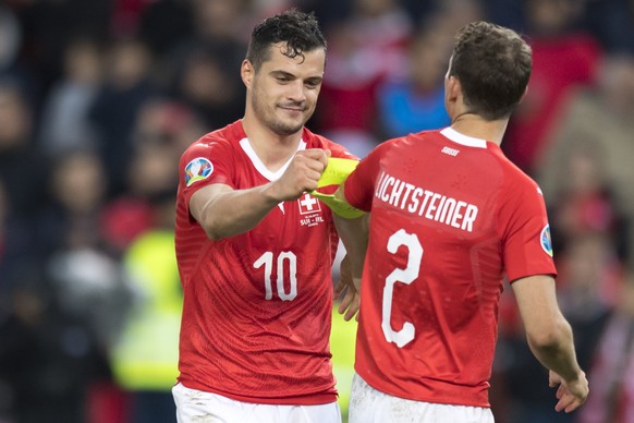Switzerland&#039;s midfielder Granit Xhaka, left, gives back the captain armband to Switzerland&#039;s defender Stephan Lichtsteiner, right, after the UEFA Euro 2020 qualifying Group D soccer match be ...