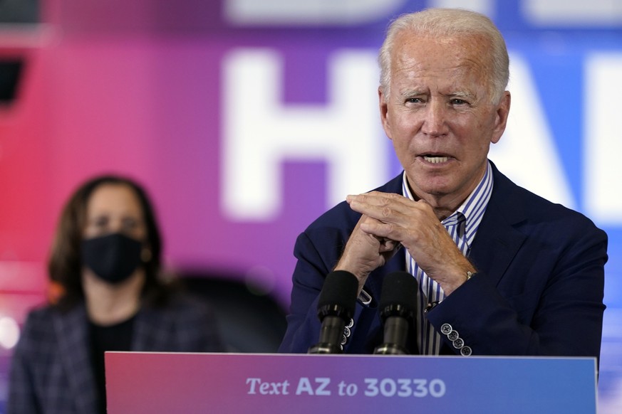 Democratic presidential candidate former Vice President Joe Biden speaks as Democratic vice presidential candidate Sen. Kamala Harris, D-Calif., listens at the Carpenters Local Union 1912 in Phoenix,  ...
