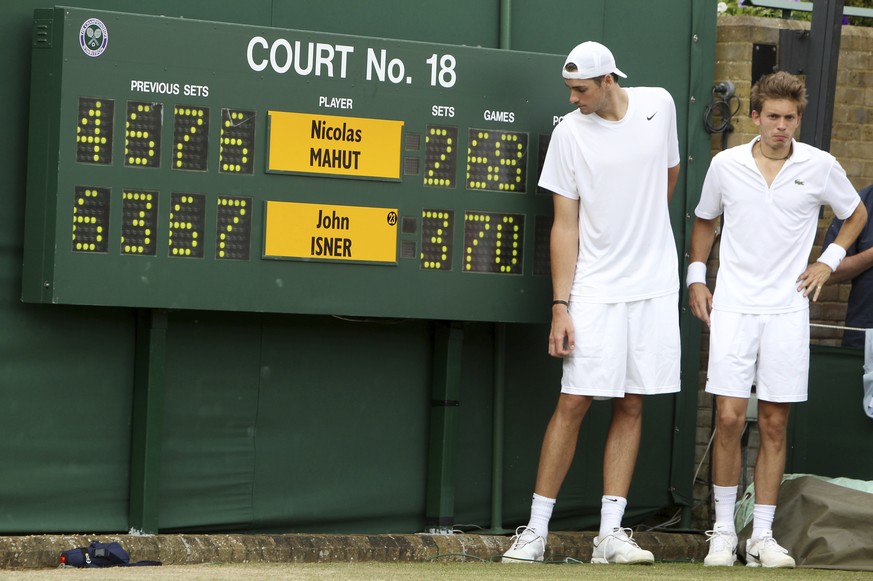 FILE - In this June 24, 2010, file photo, John Isner of the United States, left, and France&#039;s Nicolas Mahut pose for a photo next to the scoreboard following their epic men&#039;s singles match a ...