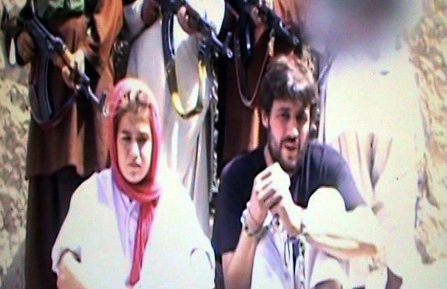 epa02979934 A video grab taken from the video released by Taliban militants and made available to media on 25 October 2011, shows Swiss couple Olivier David Och, 31, (R) and Daniela Widmer, 28, (L), a ...
