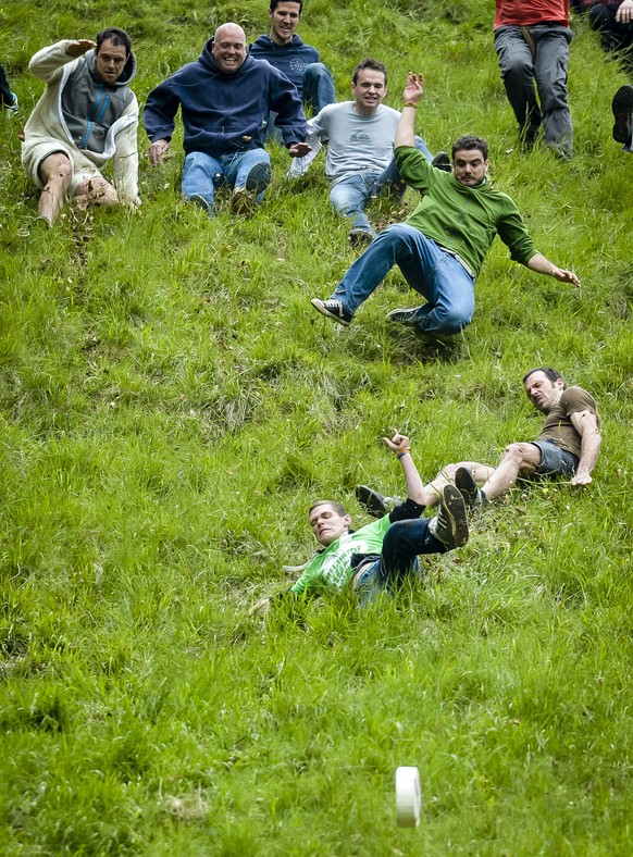 A man crashes and tumbles as he chases after the Double Gloucester cheese as it hurtles down Coopers Hill, Gloucestershire, in the annual Cheese Rolling competition, which is being held unofficially t ...