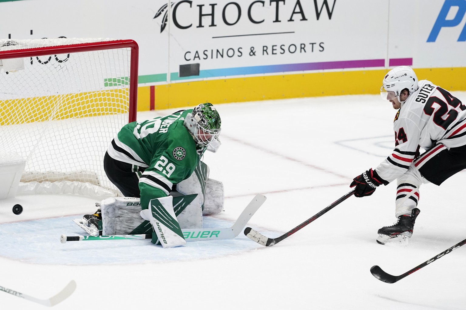 Dallas Stars goaltender Jake Oettinger (29) is unable to stop a shot by Chicago Blackhawks&#039; Pius Suter (24) in overtime of an NHL hockey game in Dallas, Tuesday, Feb. 9, 2021. The Blackhawks won  ...