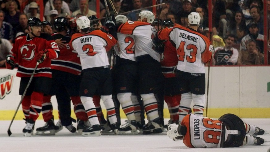 Players from the Philadelphia Flyers and the New Jersey Devils scuffle in the background as Philadelphia Flyers Eric Lindros (88) lies on the ice after getting hit in the first period of Game 7 of the ...