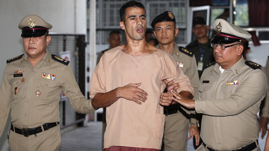 epa07341692 Bahraini soccer player with Australian refugee status Hakeem Al-Araibi (C) speaks to journalists as he is escorted by Thai prison officers prior an extradition hearing at the Criminal Cour ...