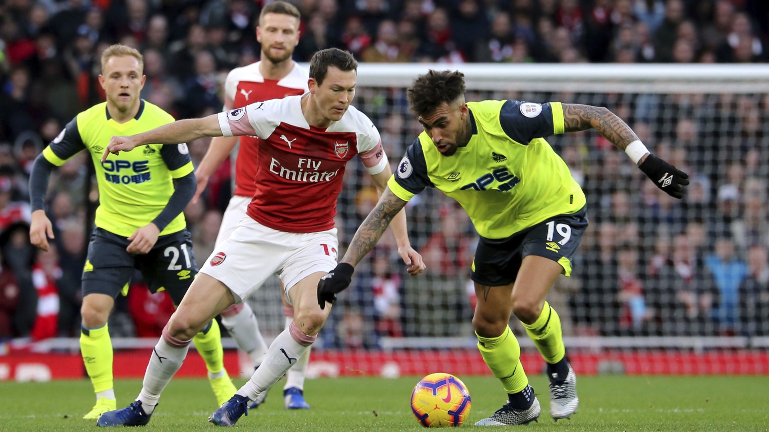 Huddersfield Town&#039;s Daniel Williams, right, and Arsenal&#039;s Stephan Lichtsteiner battle for the ball during their English Premier League soccer match at the Emirates Stadium, London, Saturday, ...