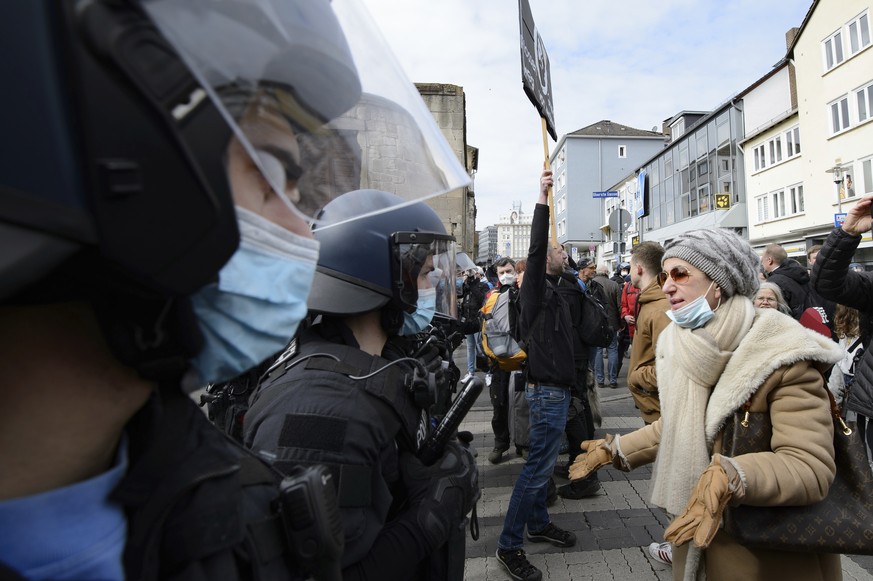 A woman speaks to police officers on duty at a rally under the motto &quot;Free citizens Kassel - basic rights and democracy&quot; in Kassel, Germany, Saturday, March 20, 2021. According to police, se ...
