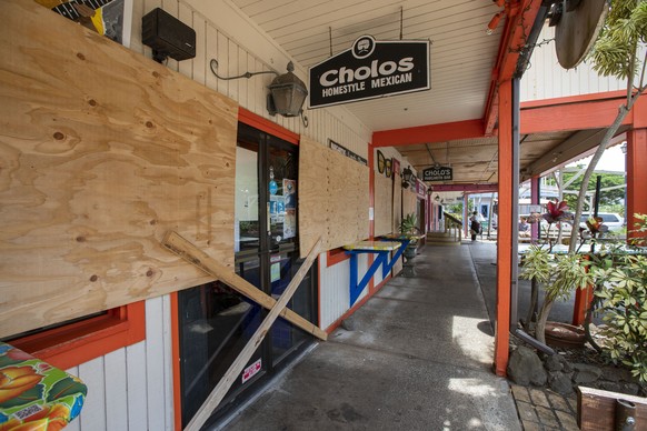 Some businesses in the North Shore Marketplace in Haleiwa, Hawaii, are boarded up and closed in anticipation of Hurricane Douglas, Sunday, July 26, 2020, on the island of Oahu. Heavy rain and wind gus ...