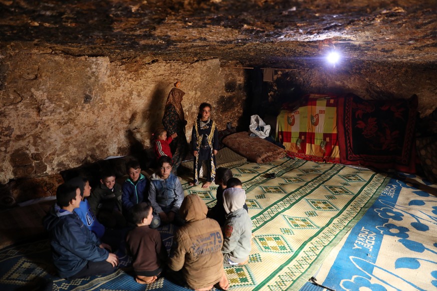 epa08237988 A group of displaced Syrians look on as they sit in an underground shelter in the Taltouna village, 17kms northwest of the city of Idlib, Syria, 22 February 2020. According to local source ...