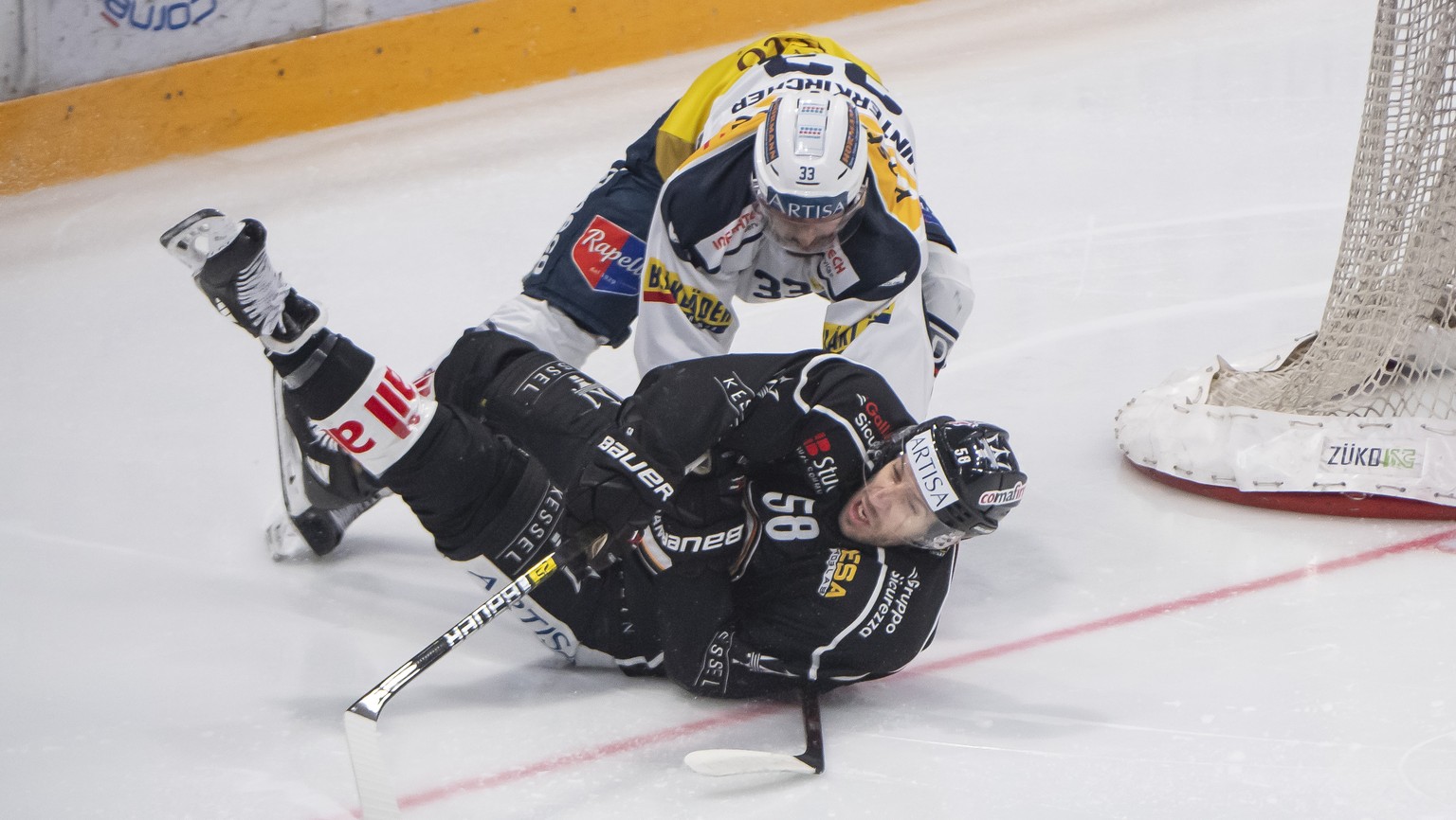From left, Ambri&#039;s player Mattia Hinterkircher and Lugano&#039;s player Romain Loeffel, during the preliminary round game of National League A (NLA) Swiss Championship 2019/20 between HC Lugano a ...