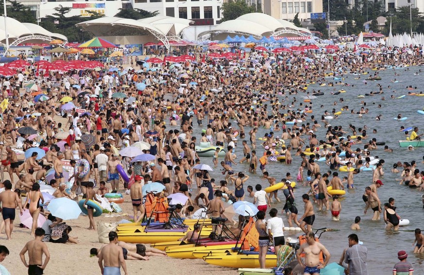 In this photo released by the Chinese news agency Xinhua tourists and citizens frolic on the bathing beach in Qingdao, east China&#039;s Shandong province, on Thursday July 17, 2008. The costal city i ...