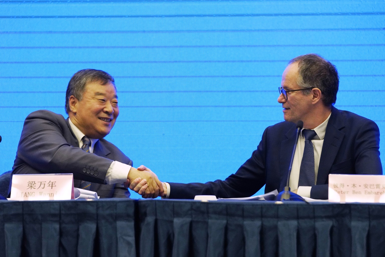 Peter Ben Embarek, of the World Health Organization team, right, shakes hands with his Chinese counterpart Liang Wannian after a WHO-China Joint Study Press Conference held at the end of the WHO missi ...