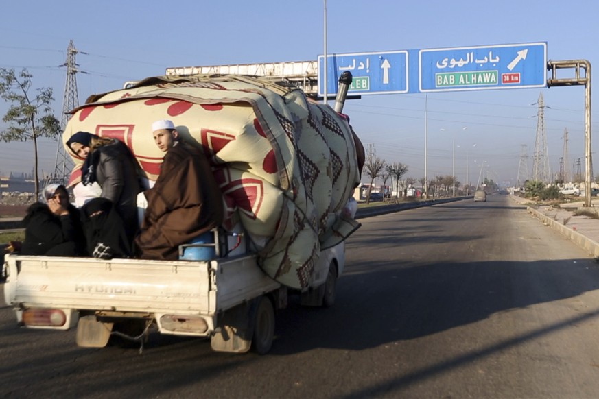 In this frame grab from video taken on Thursday, Dec. 19, 2019, a family with their goods loaded on a lorry drives towards the Turkish border in Syria&#039;s rebel-controlled Idlib province. The UN sa ...