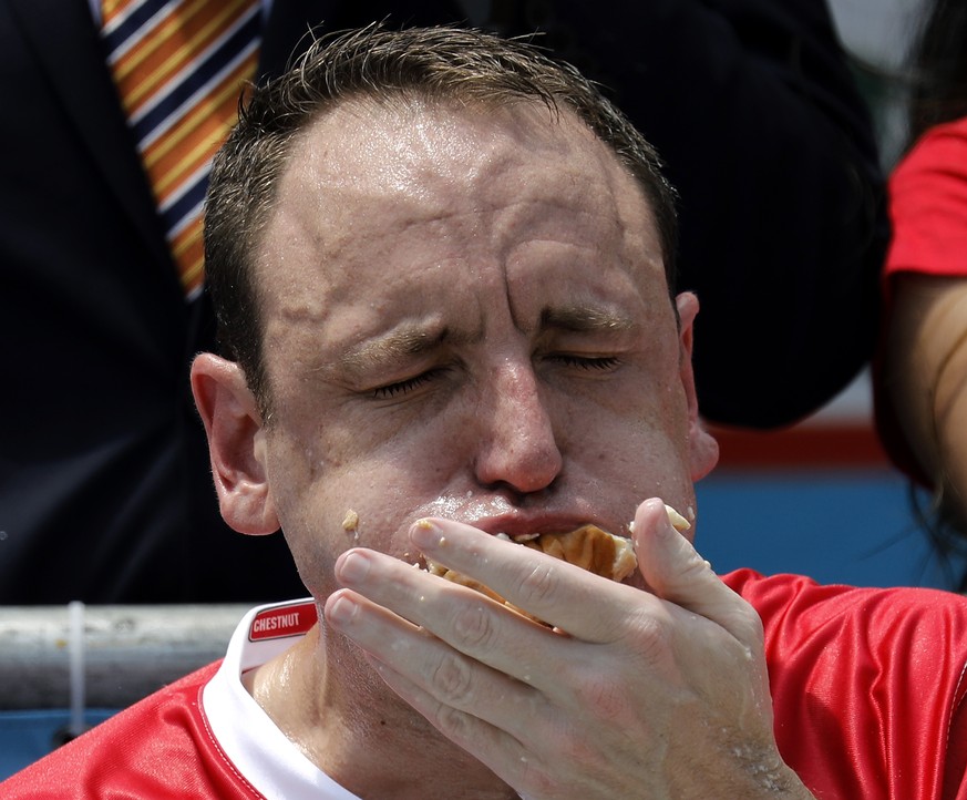 epa06864341 Champion eater Joey Chestnut swallows hot dogs during the Nathan&#039;s Famous Fourth of July International Hot-dog eating contest in Coney Island, New York, USA, 04 July 2018. Chestnut we ...