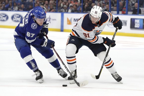 Tampa Bay Lightning&#039;s Mitchell Stephens, left, and Edmonton Oilers&#039; Gaetan Haas, of Switzerland, reach for the puck during the first period of an NHL hockey game Thursday, Feb. 13, 2020, in  ...