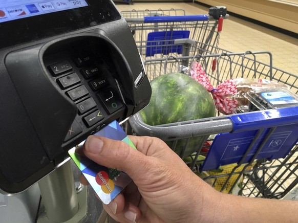 FILE- In this July 17, 2018 photo, a customer buys groceries with a credit card in Salem, N.H. Cheapskates and low spenders aren’t the ideal credit card customers for banks because they’re typically n ...