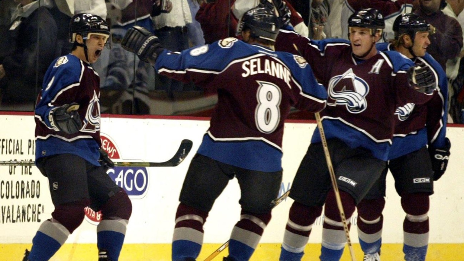 Colorado Avalanche left wing Paul Kariya (L) celebrates his first goal as an Avalanche with teammates Teemu Selanne (8) of Finland and defensemen Adam Foote (A) and Bates Battaglia in the first period ...