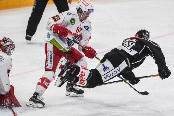 Rapperswil&#039;s player Florian Schmuckli, left, fights for the puck with Lugano?s player David McIntyre, right, during the preliminary round game of National League A (NLA) Swiss Championship 2019/2 ...