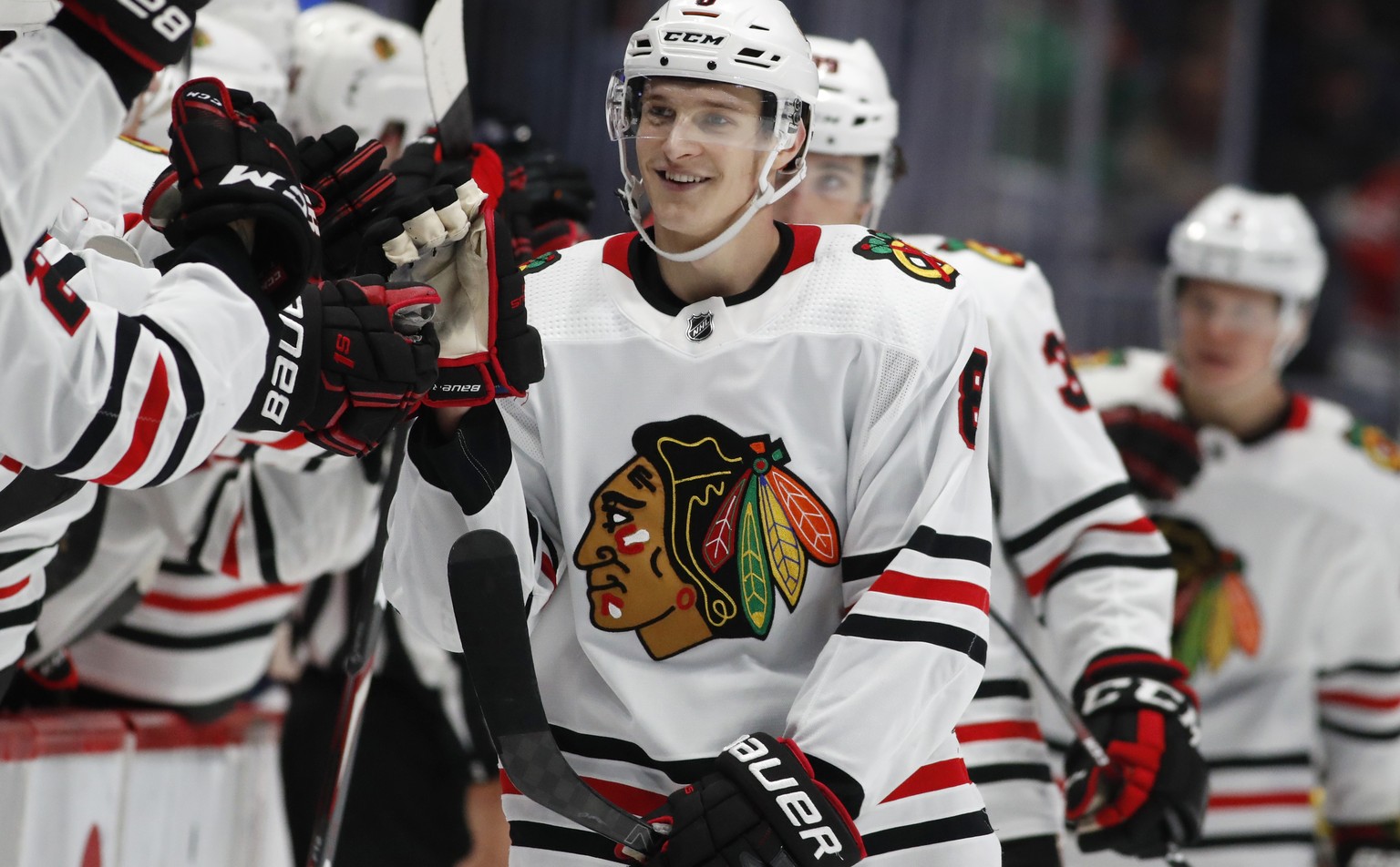 Chicago Blackhawks left wing Dominik Kubalik, center, smiles as he is congratulated while passing the team box after scoring the go-ahead goal against the Colorado Avalanche during the third period of ...