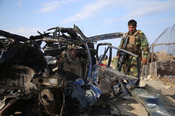 epa09356801 Afghan security officials inspect the scene of a road side bomb blast that killed six civilians on the outskirts of Jalalabad, Afghanistan, 21 July 2021. The Afghan government and the Tali ...