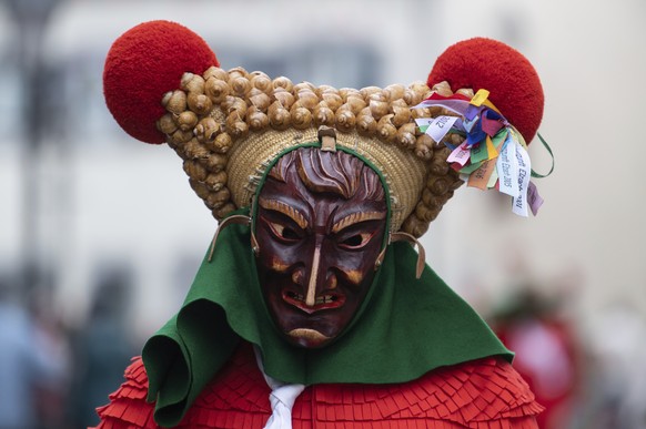 A fool of the Elzacher Schuttig walks through the main street during the traditional Schuttig jump carnival parade in Elzach, Germany, Sunday, Feb 23, 2020. (Patrick Seeger/dpa via AP)