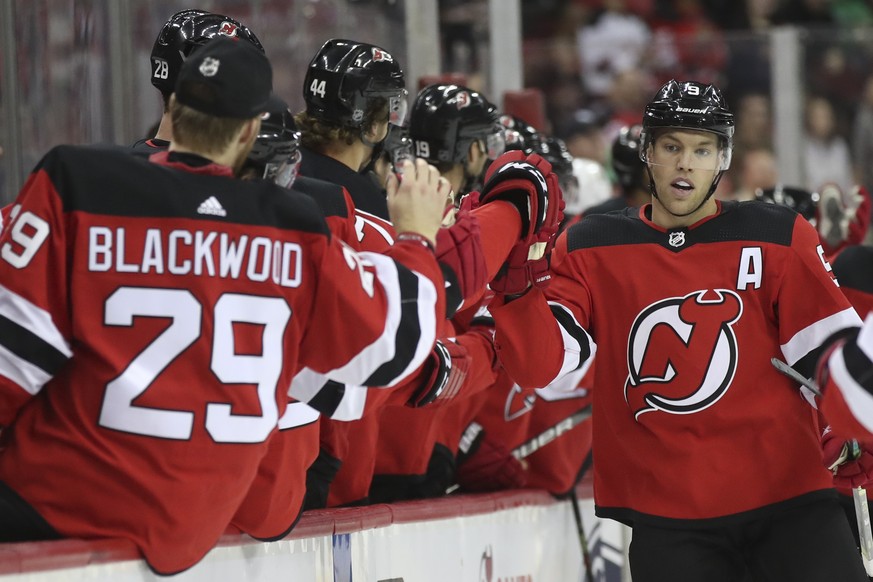 New Jersey Devils left wing Taylor Hall, right, celebrates with teammates on the bench after scoring a goal against the Florida Panthers during the first period of an NHL hockey game Monday, Oct. 14,  ...