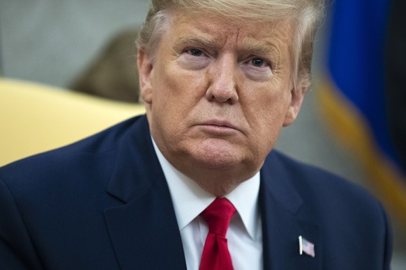 FILE - In this Tuesday, Dec. 17, 2019, file photo, President Donald Trump listens to a question during a meeting in the Oval Office of the White House, in Washington. As the political clamor caused by ...