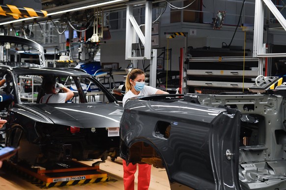 epa08486854 Workers work on the assembly line of the car manufacturing plant of Audi Hungaria Kft., an affiliate of German carmaker Audi AG, in Gyor, Hungary, 15 June 2020. The factory resumed the thr ...