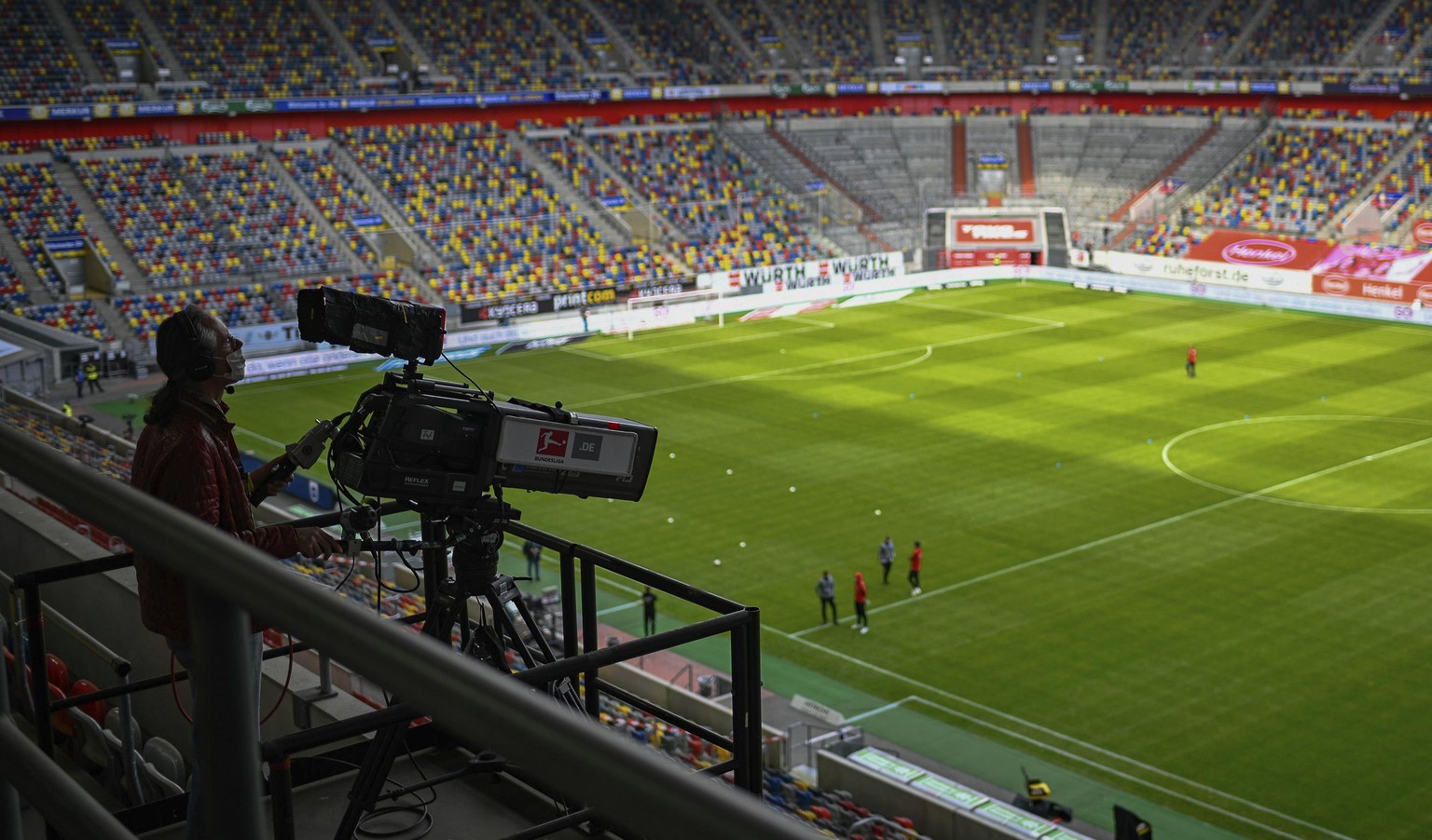 A TV camera operator works prior to the Bundesliga soccer match between Duesseldorf and Paderborn in the Merkur Spiel-Arena, Duesseldorf, Germany, Saturday, May 16, 2020. The German Bundesliga becomes ...
