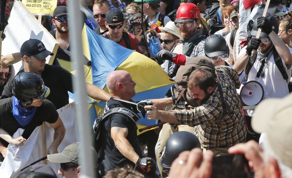 FILE - In this Aug. 12, 2017 file photo, white nationalist demonstrators clash with counter demonstrators at the entrance to Lee Park in Charlottesville, Va. Federal prosecutors say a â??hate crime mo ...