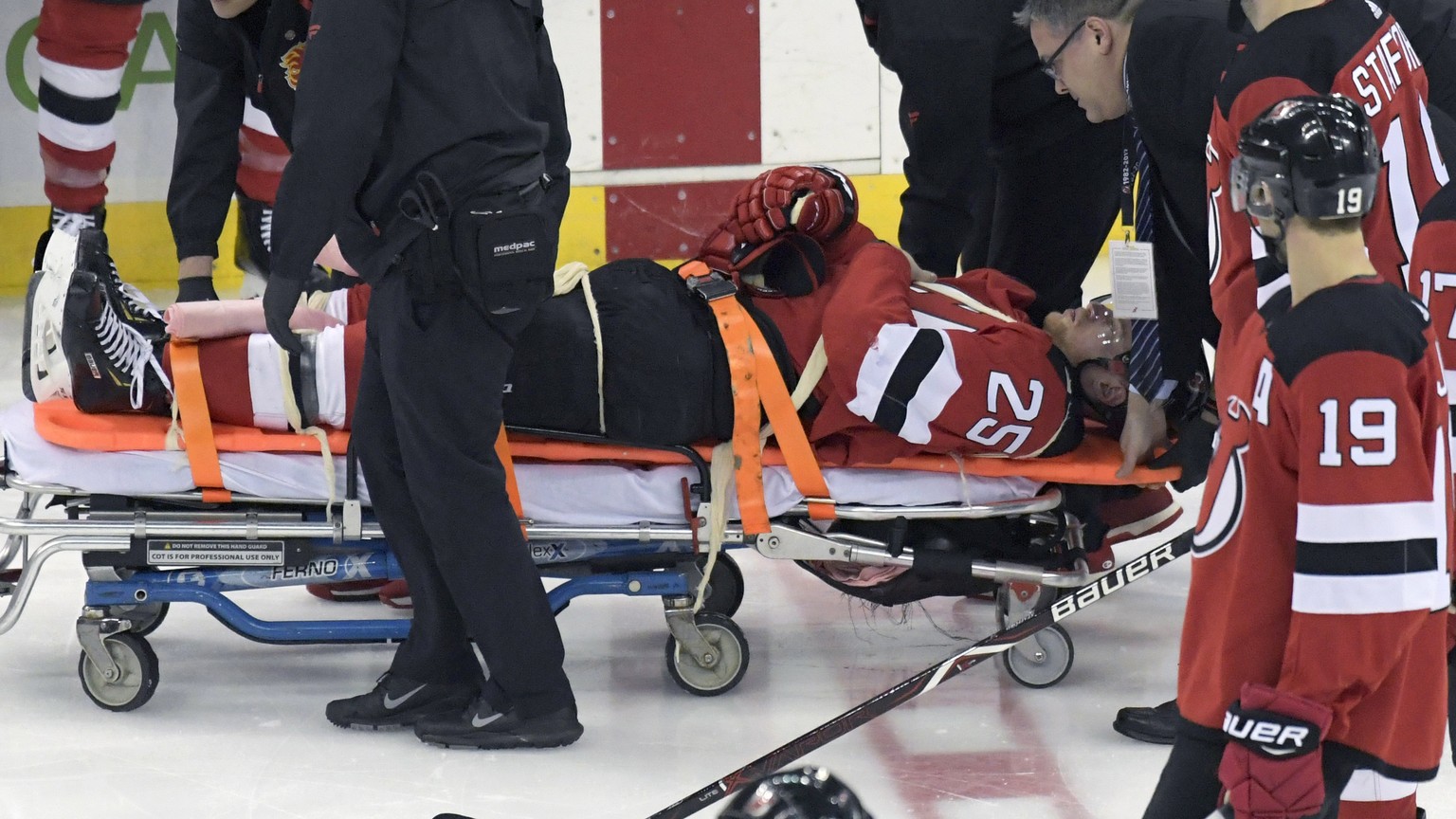 New Jersey Devils defenseman Mirco Mueller is wheeled off the ice on a stretcher after being injured during the third period of an NHL hockey game against the Calgary Flames Wednesday, Feb. 27, 2019,  ...