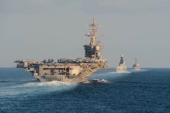 In this Tuesday, Nov. 19, 2019, photo made available by U.S. Navy, the aircraft carrier USS Abraham Lincoln, left, the air-defense destroyer HMS Defender and the guided-missile destroyer USS Farragut  ...